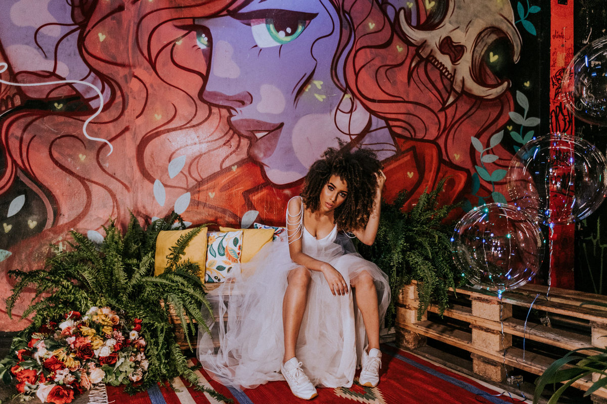 Noiva afro posando em parede de grafitti no teatro Dulcina. Foto feita por Rafael Ohana fotógrafo de casamento em Brasilia.