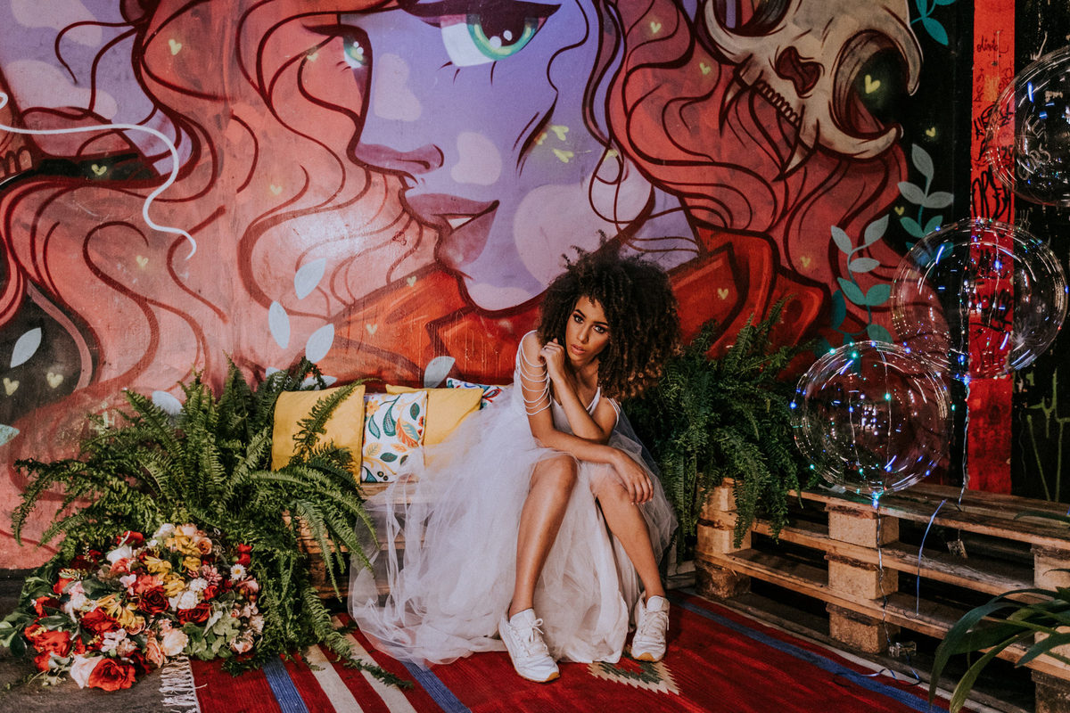 Noiva afro posando perto de parede de grafitti em Dulcina em Brasilia. Foto feita por Rafael Ohana fotógrafo de casamento em Brasilia