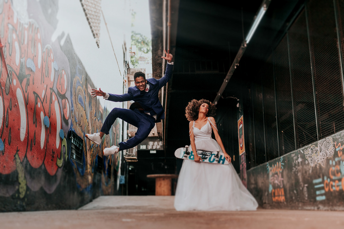 Noivo pulando com noiva segurando skate. Foto feita por Rafael Ohana fotógrafo de casamento em Brasilia