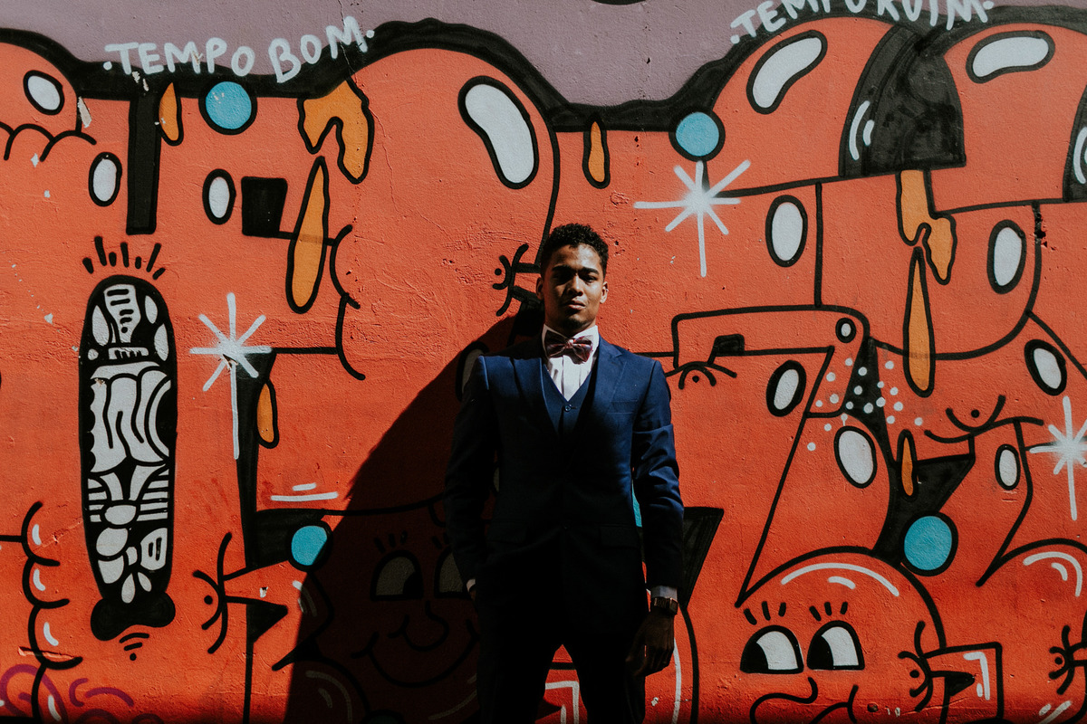 Noivo posando cm parede de grafitti. Foto feita por Rafael Ohana fotógrafo de casamento em Brasilia