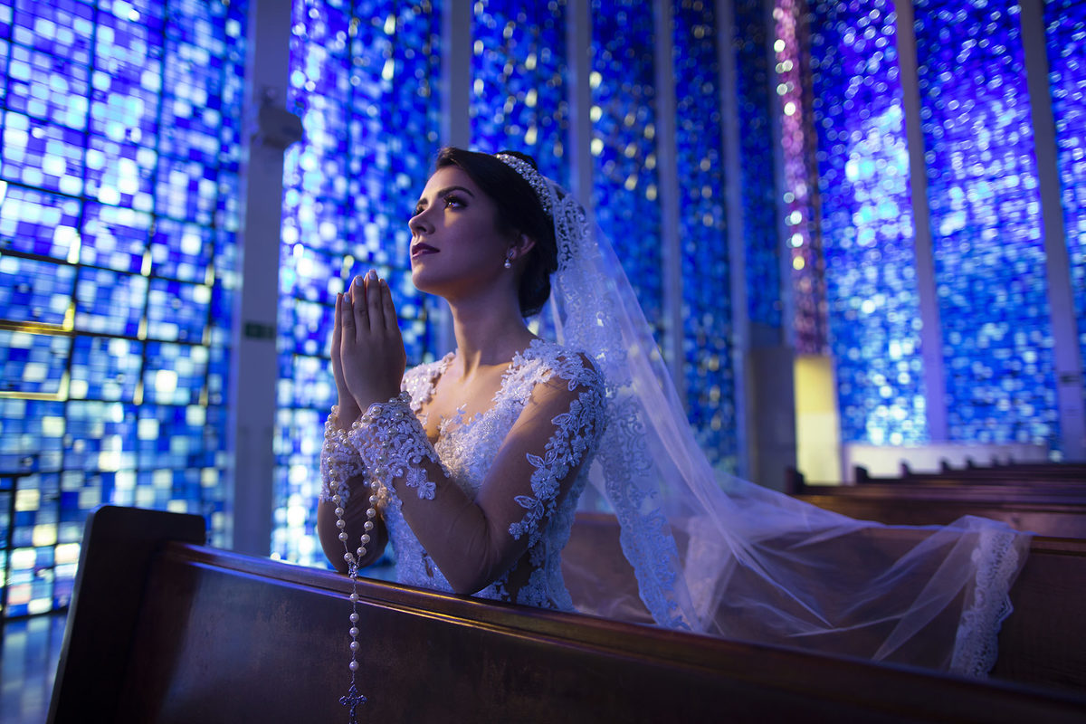 Noiva rezando no santuário Dom Bosco. Foto feita pelo fotógrafo de casamento Rafael Ohana em Brasília