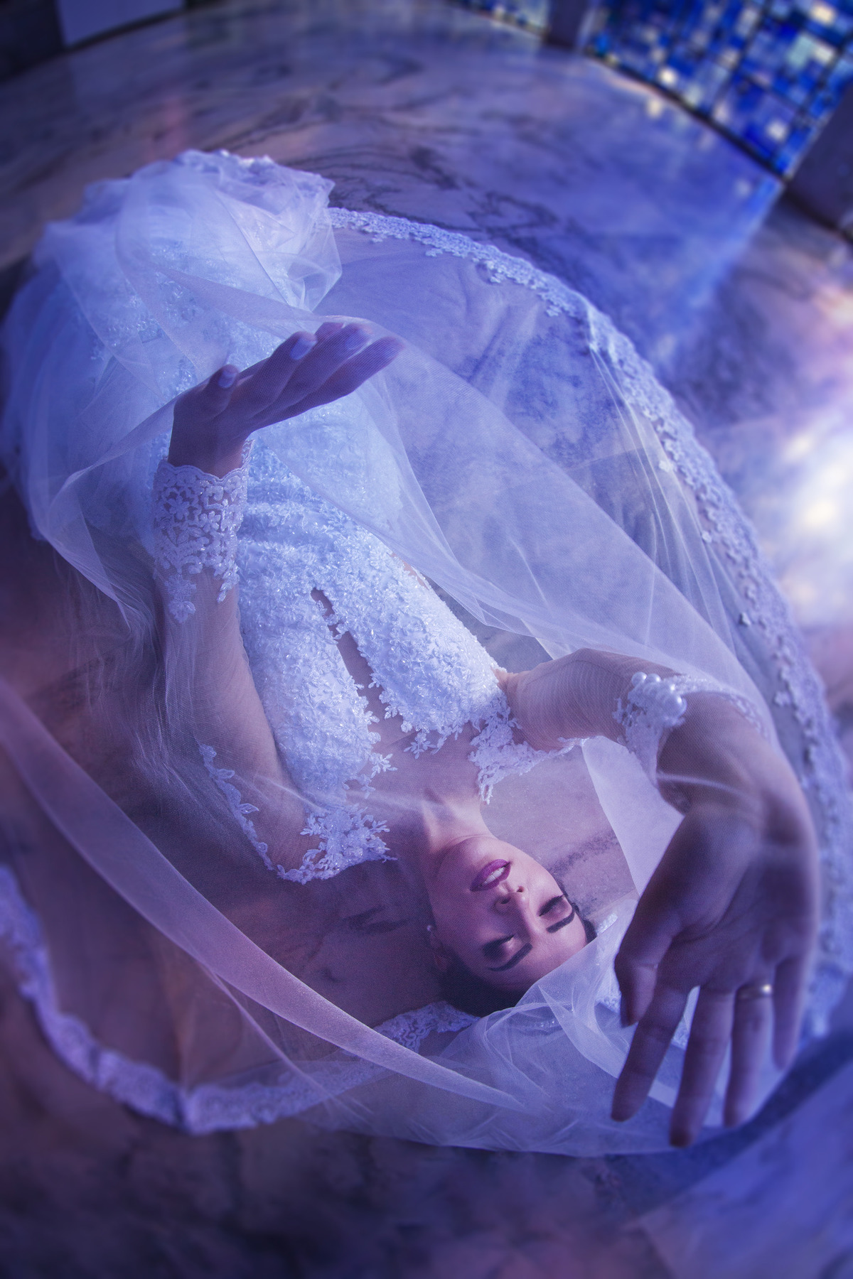 Noiva deitada com véu por cima. Foto feita pelo fotógrafo de casamento Rafael Ohana em Brasília