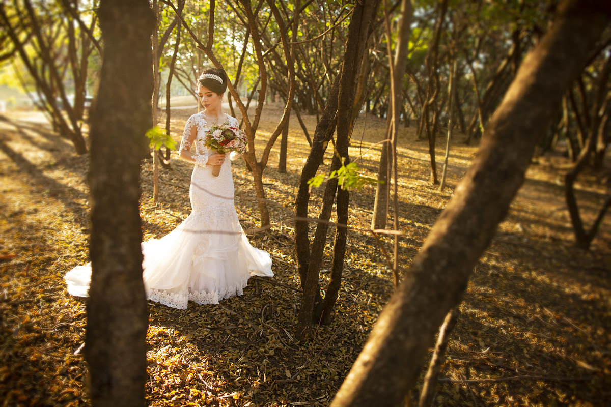 Noiva segurando buque de flores em bosque no parque olhos d´agua. Foto feita pelo fotógrafo de casamento Rafael Ohana em Brasília