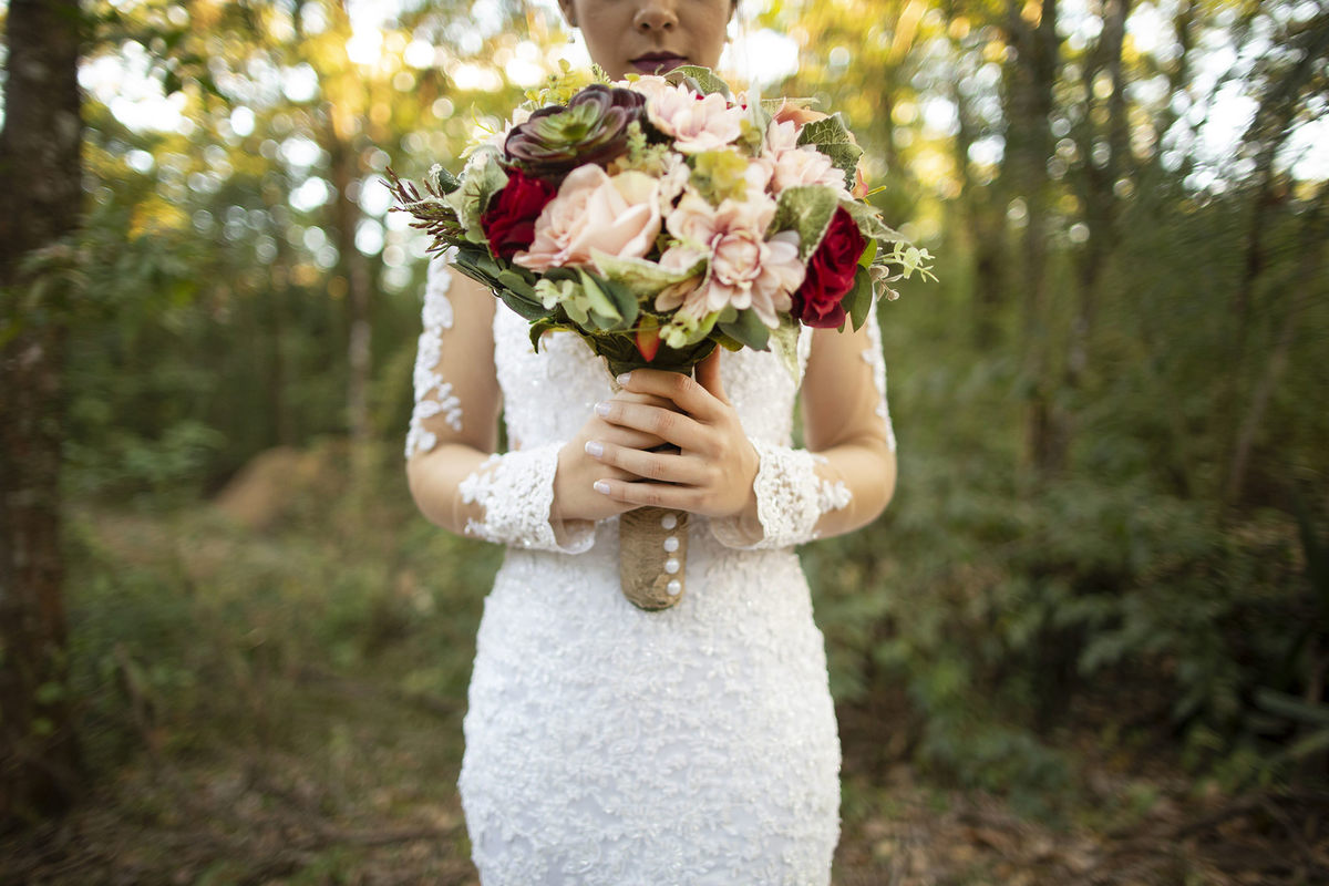 Noiva segurando buque na floresta em parque olhos dagua em brasilia. Foto feita pelo fotógrafo de casamento Rafael Ohana em Brasília