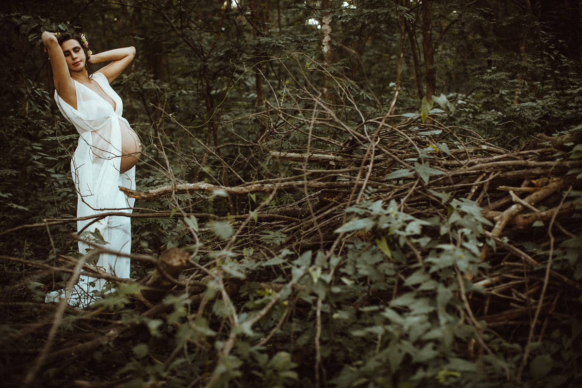 Grávida fazendo pose na floresta. Ensaio fotográfico feito pelo fotógrafo de gestante Rafael Ohana no parque olhos d´água em Brasília-DF