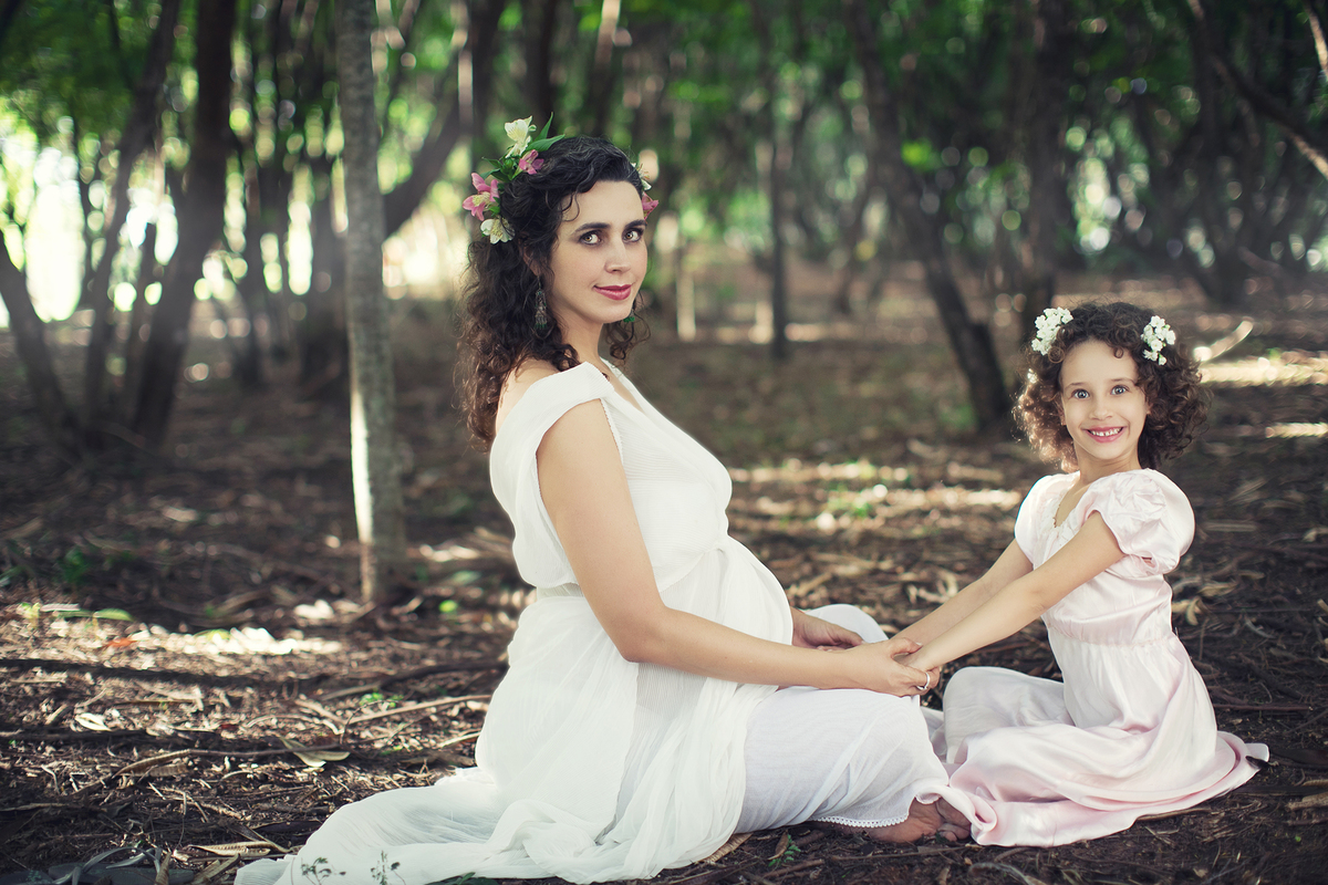 Grávida usando branco brincando com sua filha pequena. Ensaio fotográfico feito pelo fotógrafo de gestante Rafael Ohana em Brasília-DF