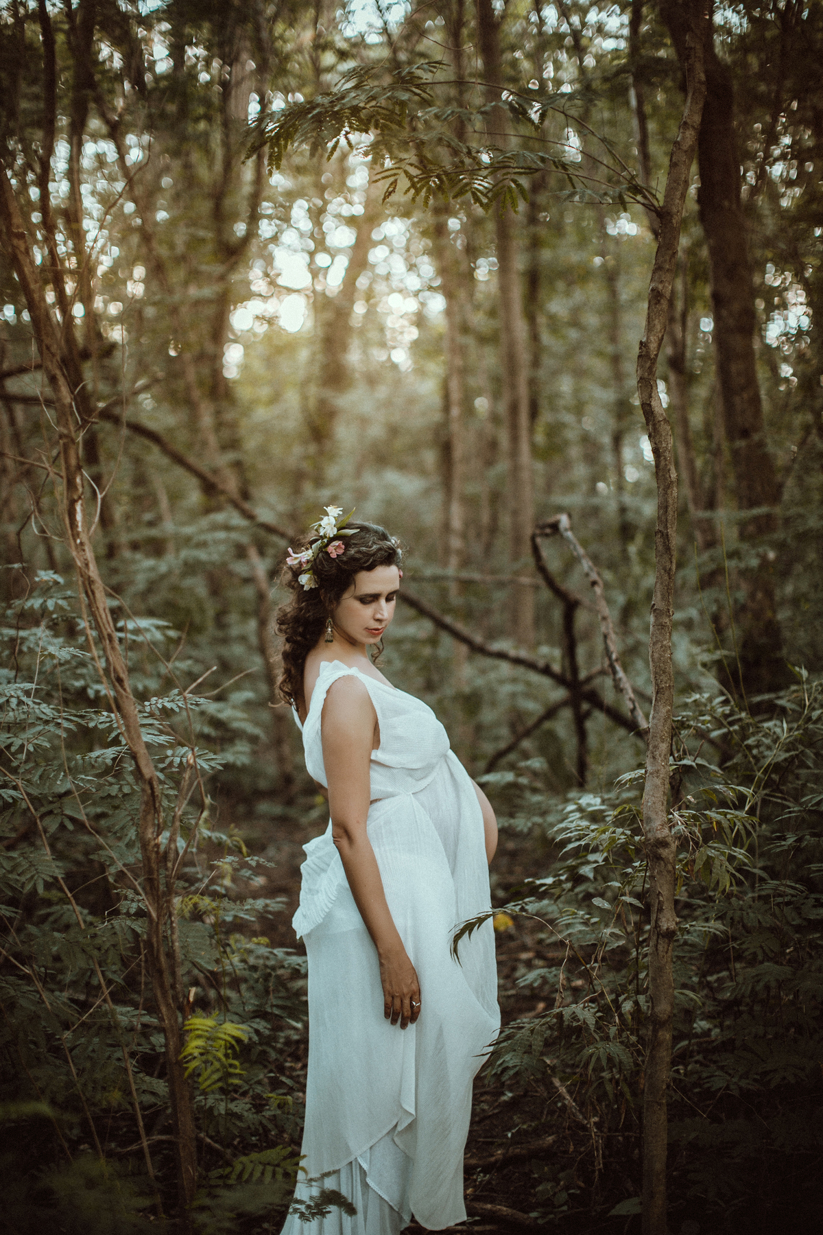 Grávida posando na floresta. Ensaio fotográfico feito pelo fotógrafo de gestante Rafael Ohana no parque olhos d´água em Brasília-DF