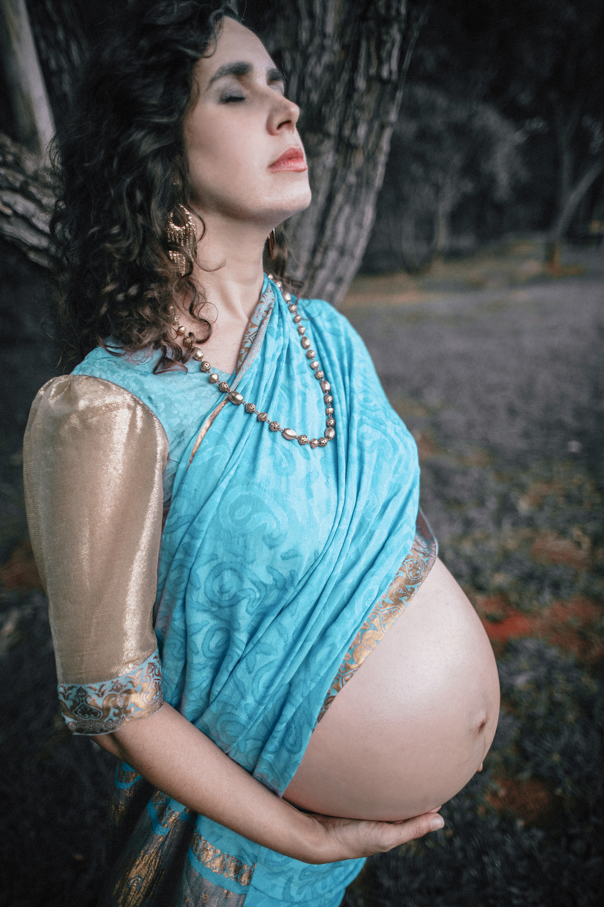Grávida usando saari meditando. Ensaio fotográfico feito pelo fotógrafo de gestante Rafael Ohana no parque olhos d´água em Brasília-DF