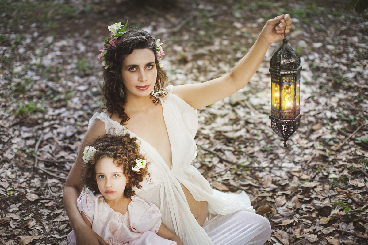 Grávida segurando sua filha e uma fada. Ensaio fotográfico feito pelo fotógrafo de gestante Rafael Ohana no parque olhos d´água em Brasília-DF