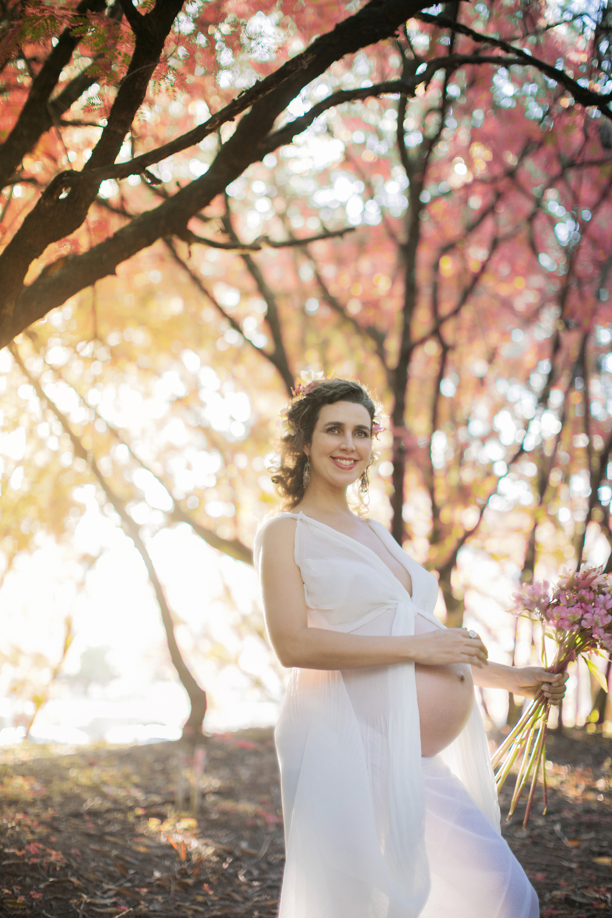 Grávida linda com flores. Ensaio fotográfico feito pelo fotógrafo de gestante Rafael Ohana no parque olhos d´água em Brasília-DF