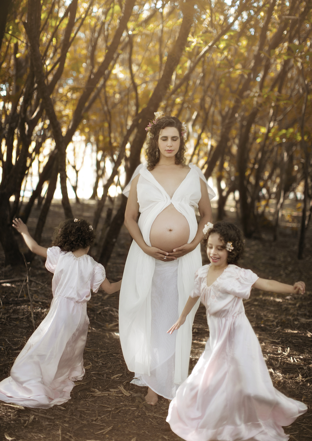 Grávida meditando com crianças correndo em volta. Ensaio fotográfico feito pelo fotógrafo de gestante Rafael Ohana no parque olhos d´água em Brasília-DF