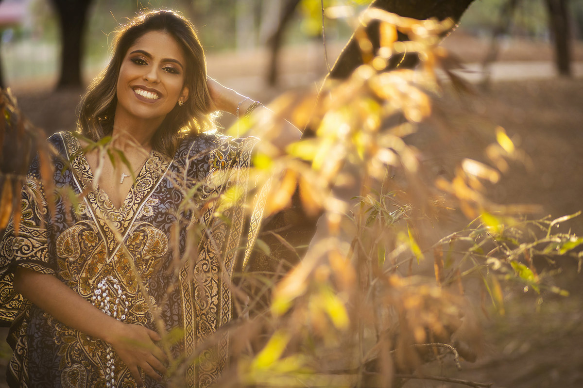 Mulher sorrindo plenamente na floresta. Ensaio feminino feito pelo fotógrafo Rafael Ohana no Parque Olhos D´água em Brasília-DF 