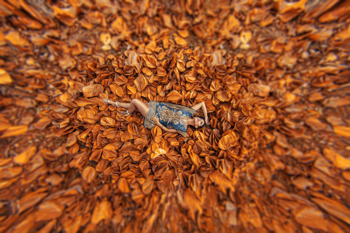 Mulher deitada em folhas secas. Ensaio feminino feito pelo fotógrafo Rafael Ohana no Parque Olhos D´água em Brasília-DF 