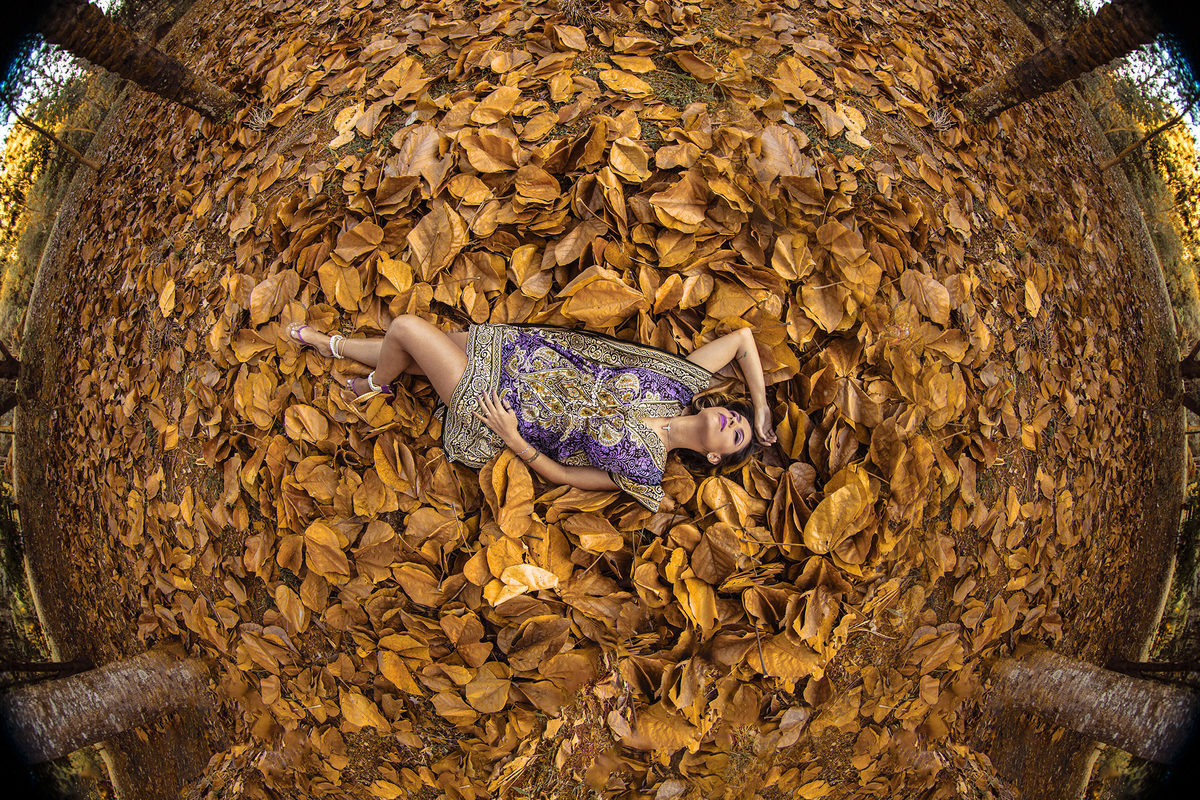 Mulher deitada em folhas secas. Ensaio feminino feito pelo fotógrafo Rafael Ohana no Parque Olhos D´água em Brasília-DF 