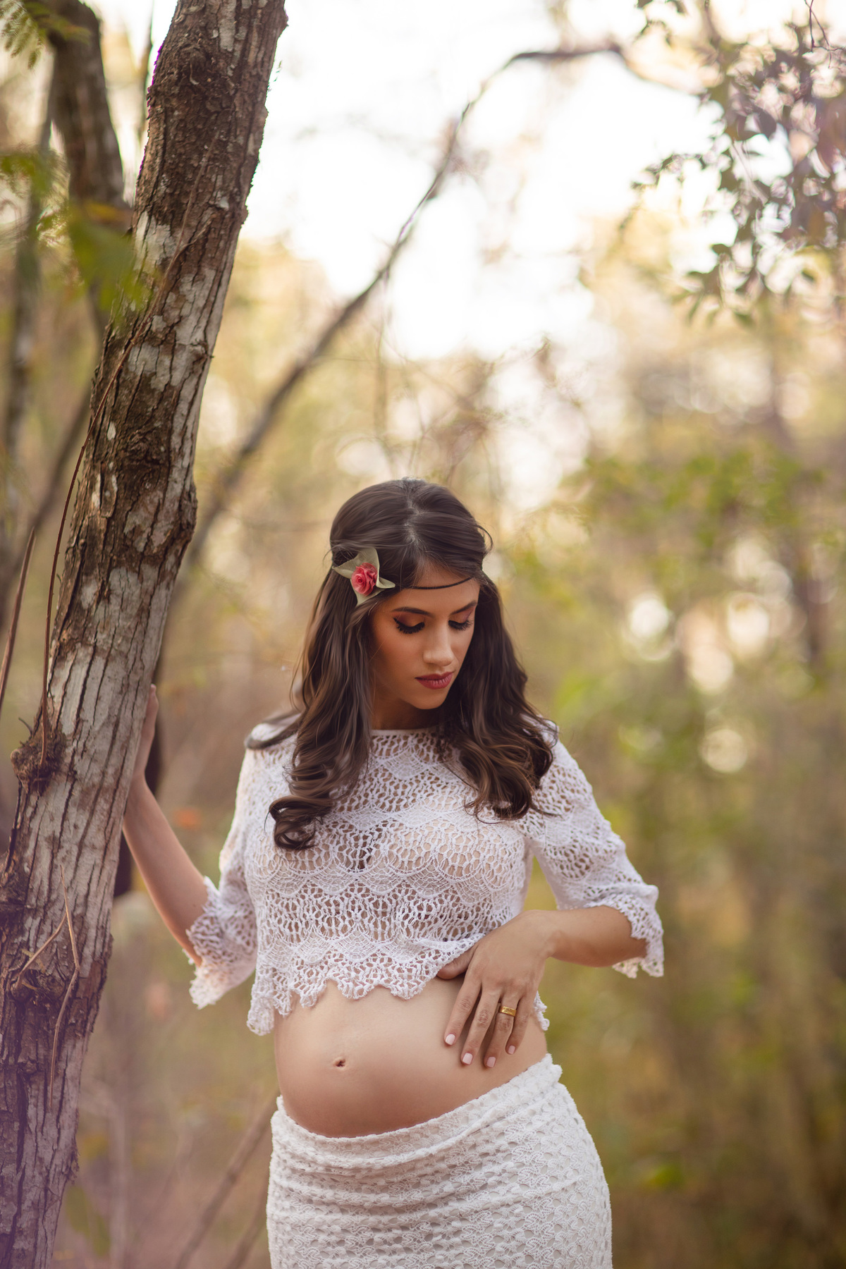 Grávida encostada em arvore na floresta. Foto feita pelo fotógrafo Rafael Ohana no parque Olhos D´água em Brasília-DF.