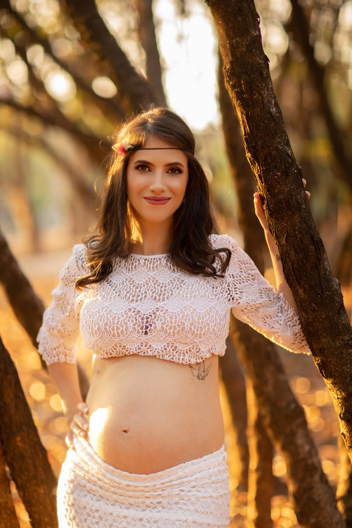 Grávida sorrindo na floresta. Foto feita pelo fotógrafo Rafael Ohana no parque Olhos D´água em Brasília-DF.