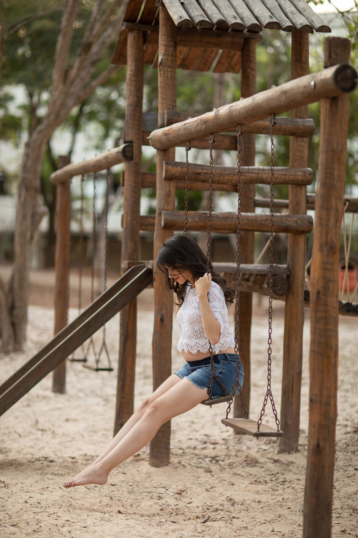 Grávida brincando no parquinho. Foto feita pelo fotógrafo Rafael Ohana no parque Olhos D´água em Brasília-DF.