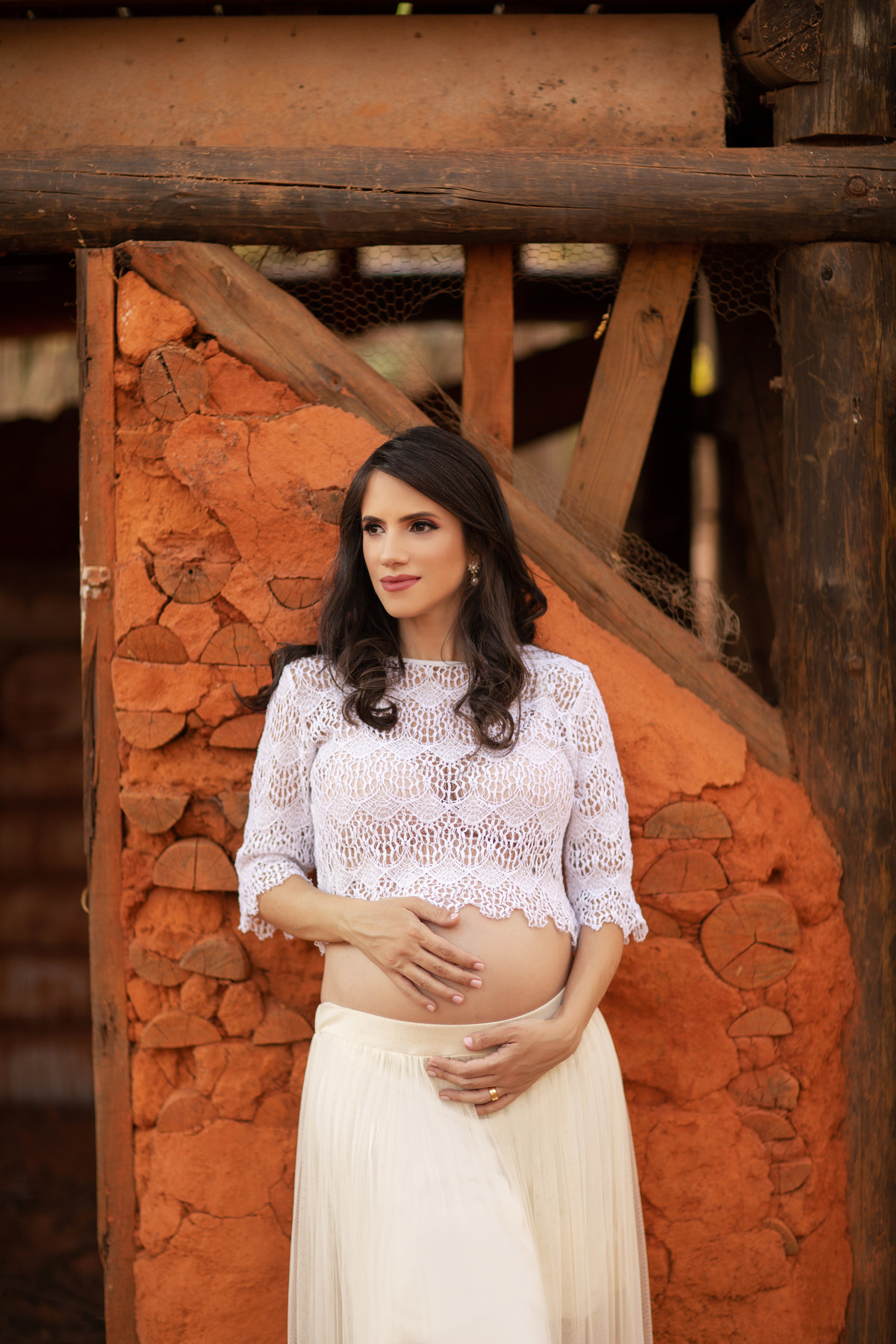 Gestante encostada em casa de barro batido. Foto feita pelo fotógrafo Rafael Ohana no parque Olhos D´água em Brasília-DF.
