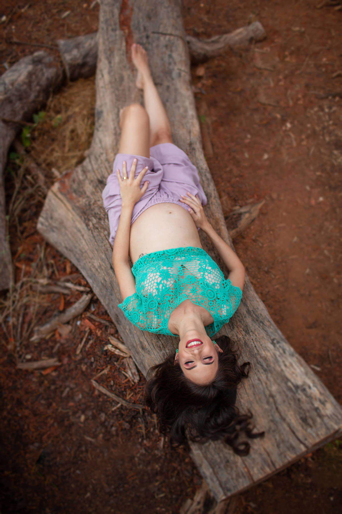 Grávida deitada em tronco de arvore. Foto feita pelo fotógrafo Rafael Ohana no parque Olhos D´água em Brasília-DF.