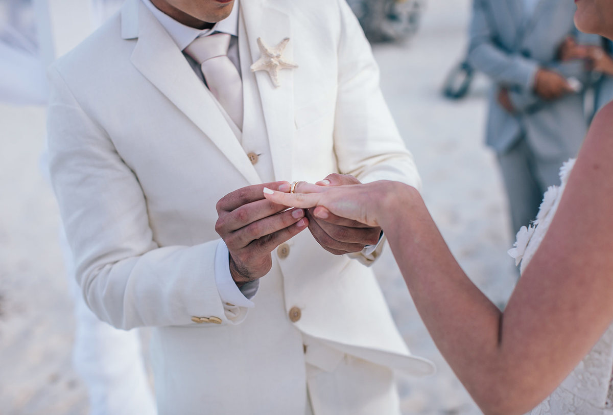 Noivo colocando aliança na noiva. Casamento realizado no resort Barceló Bávaro Palace na República Dominicana pelo fotógrafo de casamento Rafael Ohana