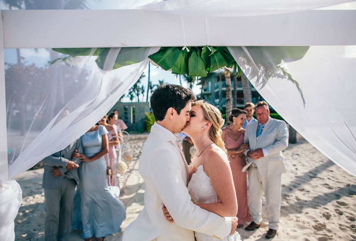 Beijo dos noivos na praia. Casamento realizado no resort Barceló Bávaro Palace na República Dominicana pelo fotógrafo de casamento Rafael Ohana