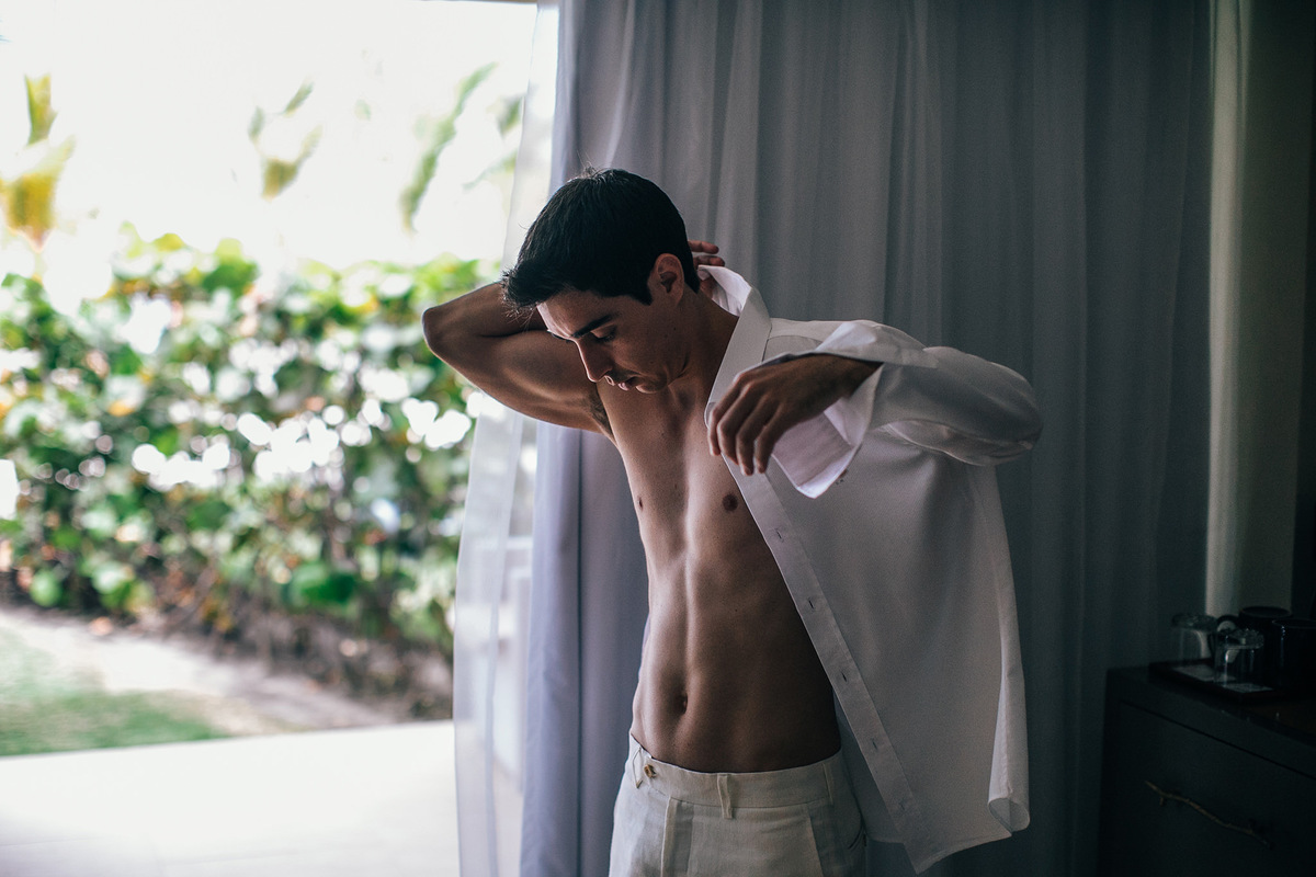 Noivo se vestindo para seu casamento na praia. Casamento realizado no resort Barceló Bávaro Palace na República Dominicana pelo fotógrafo de casamento Rafael Ohana