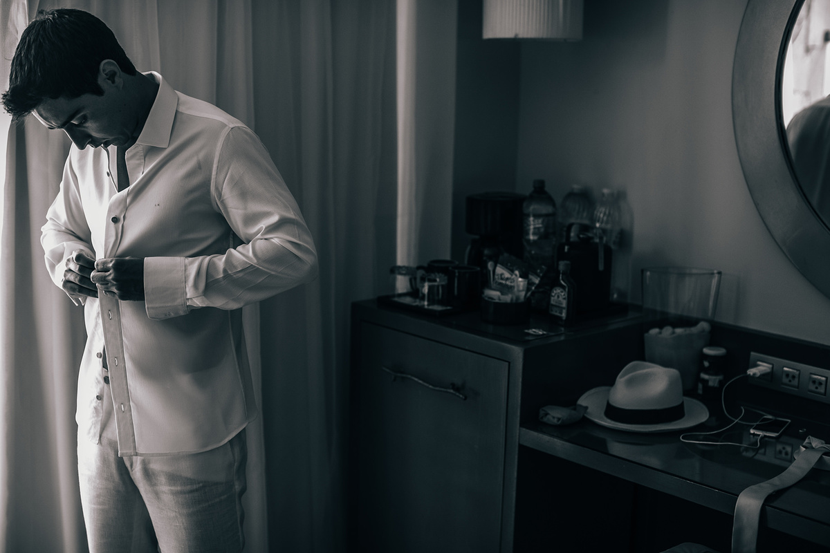 Noivo se vestind para seu casamento na praia. Casamento realizado no resort Barceló Bávaro Palace na República Dominicana pelo fotógrafo de casamento Rafael Ohana