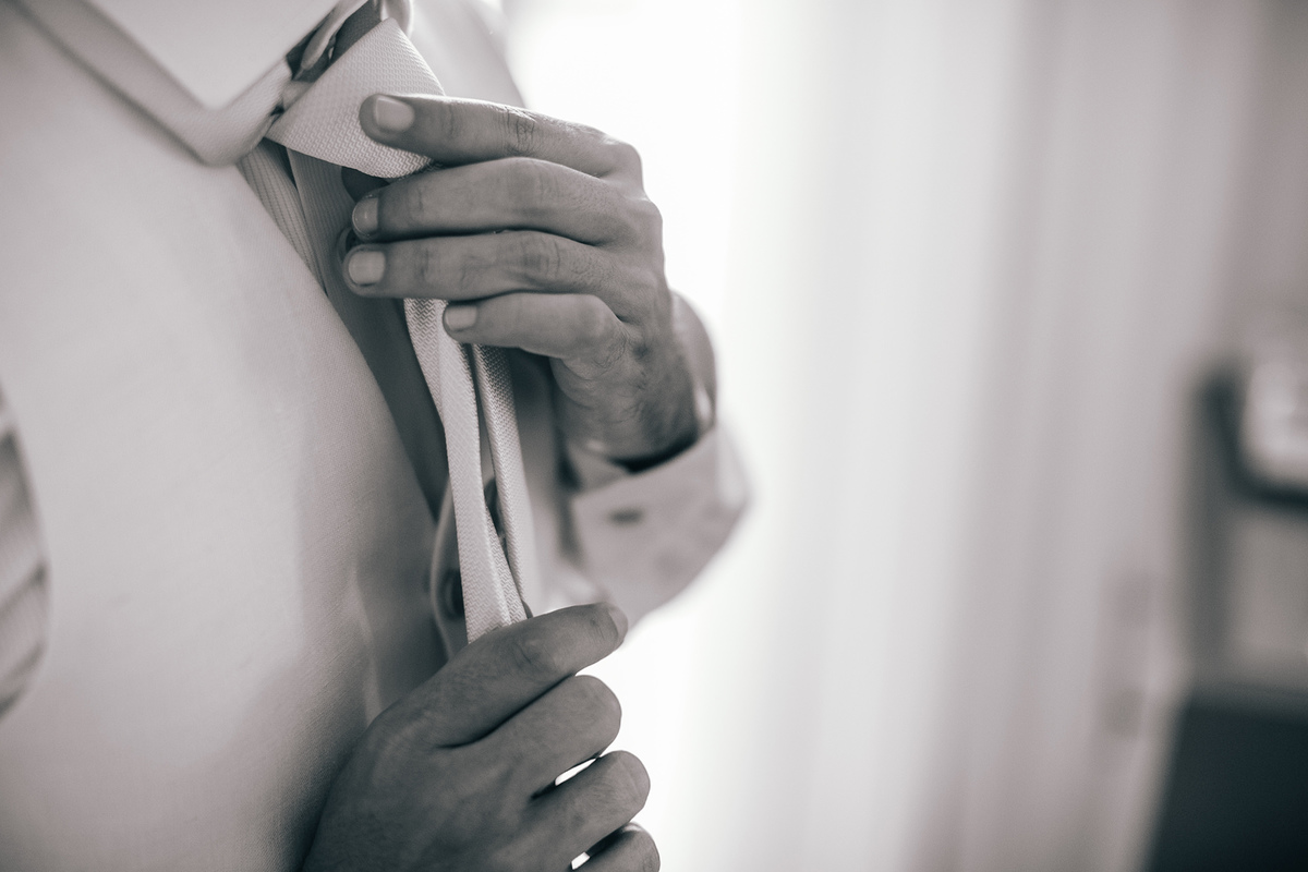 Noivo vestindo a gravata. Casamento realizado no resort Barceló Bávaro Palace na República Dominicana pelo fotógrafo de casamento Rafael Ohana