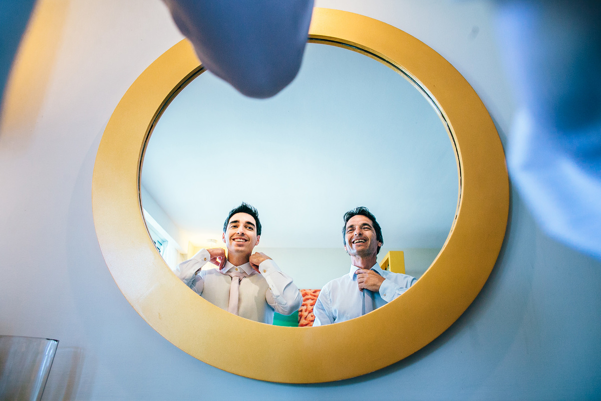 Pai do noivo se arrumando com o seu filho em resort. Casamento realizado no resort Barceló Bávaro Palace na República Dominicana pelo fotógrafo de casamento Rafael Ohana