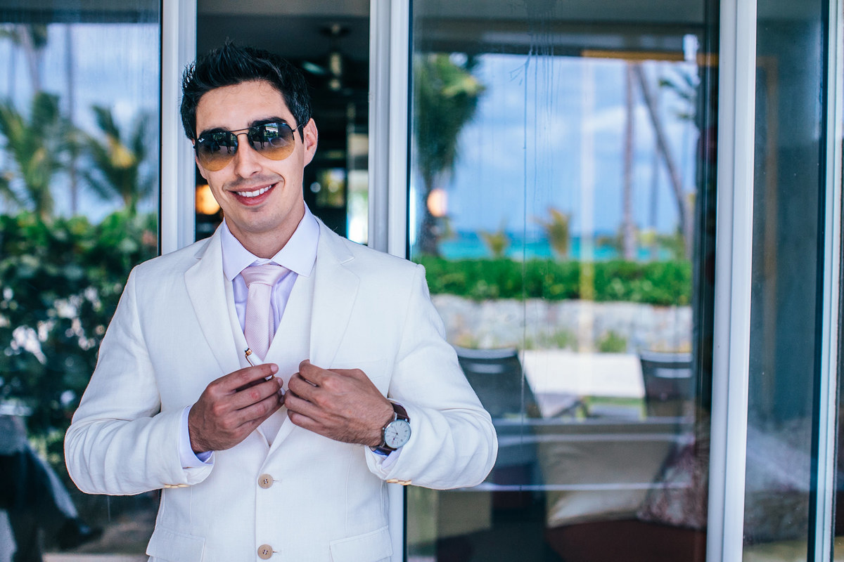 Noivo se arrumando para seu casamento na praia. Casamento realizado no resort Barceló Bávaro Palace na República Dominicana pelo fotógrafo de casamento Rafael Ohana