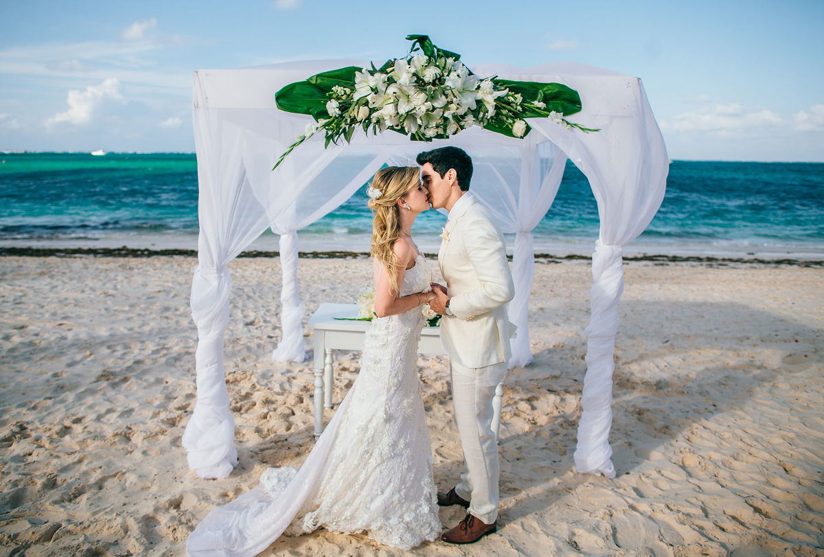 Noivos se beijando no casamento de praia. Casamento realizado no resort Barceló Bávaro Palace na República Dominicana pelo fotógrafo de casamento Rafael Ohana