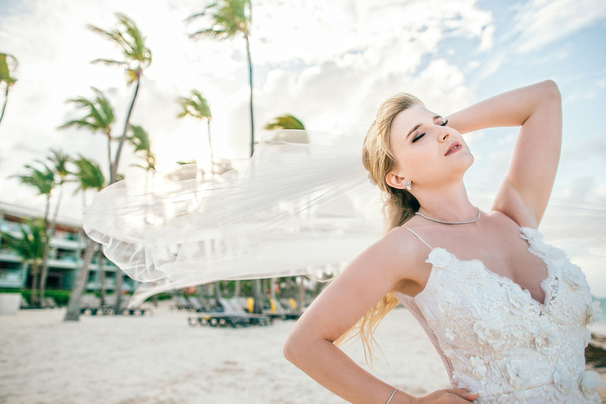 Noiva com véu voando. Casamento de praia realizado no resort Barceló Bávaro Palace na República Dominicana pelo fotógrafo de casamento Rafael Ohana