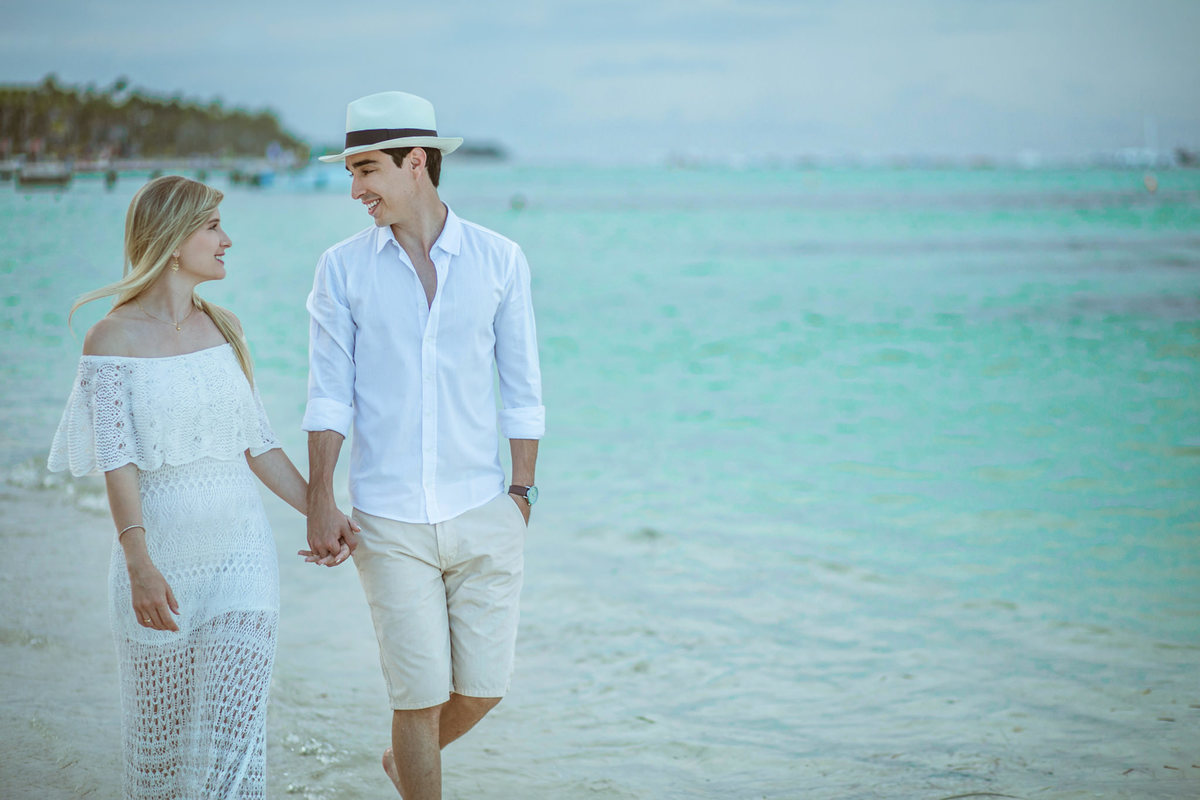 Noivos caiminhando em praia do Caribe. Ensaio de romântico na praia realizado no resort Barceló Bávaro Palace na República Dominicana pelo fotógrafo de casamento Rafael Ohana