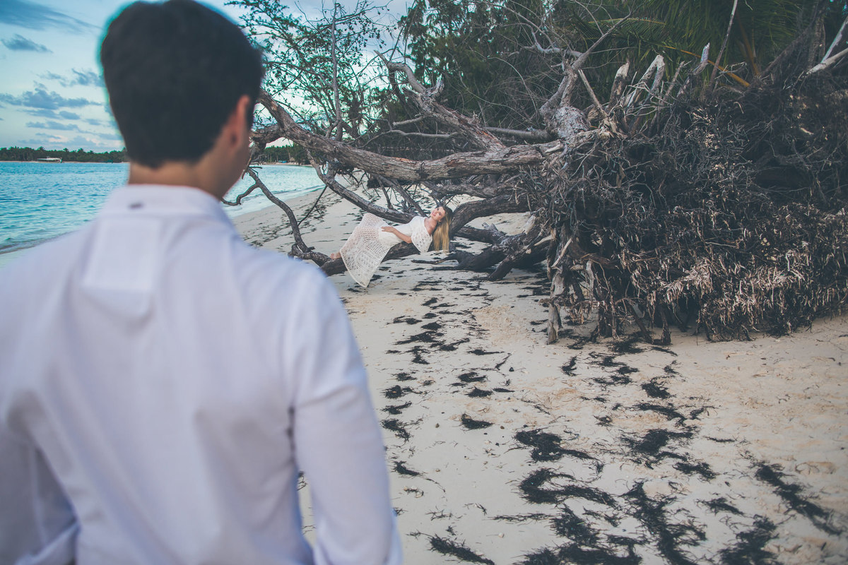 Noivo olhando a noiva de longe. Ensaio de romântico na praia realizado no resort Barceló Bávaro Palace na República Dominicana pelo fotógrafo de casamento Rafael Ohana