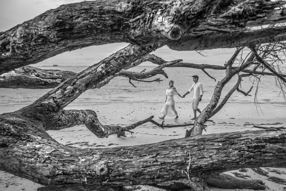 Noivos passeando na praia. Ensaio de romântico na praia realizado no resort Barceló Bávaro Palace na República Dominicana pelo fotógrafo de casamento Rafael Ohana