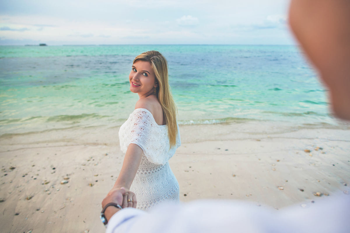 Noiva olhando para o noivo. Ensaio de romântico na praia realizado no resort Barceló Bávaro Palace na República Dominicana pelo fotógrafo de casamento Rafael Ohana