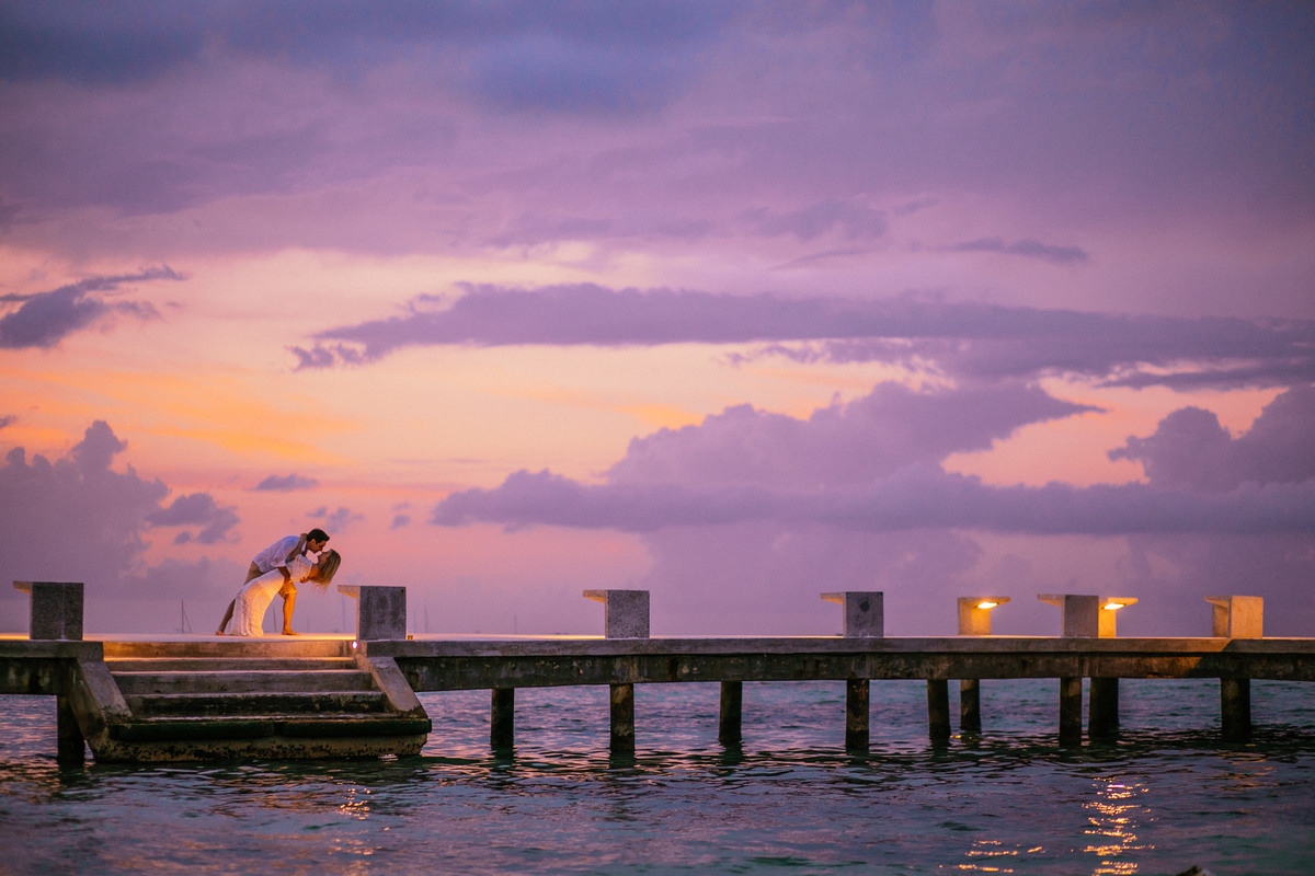 Noivos se beijando ao por do sol. Ensaio de romântico na praia realizado no resort Barceló Bávaro Palace na República Dominicana pelo fotógrafo de casamento Rafael Ohana