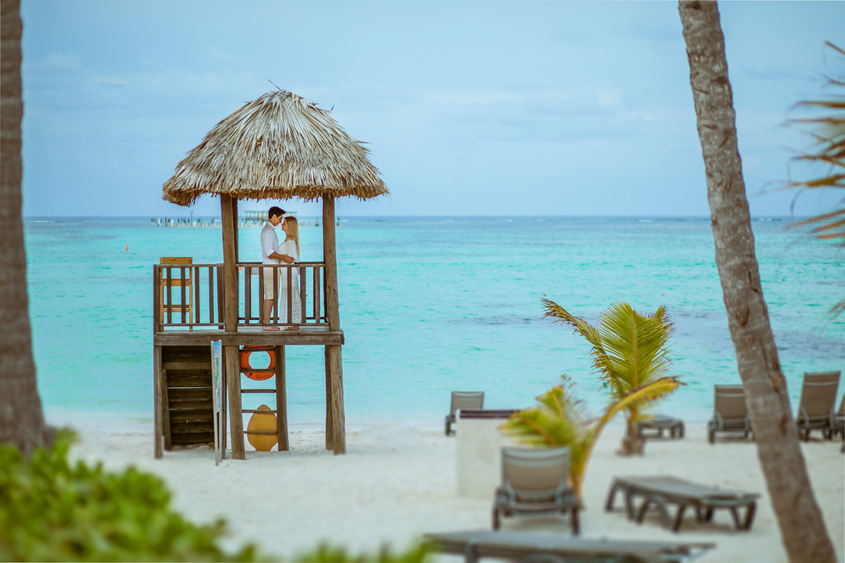 Noivos se beijando na praia. Ensaio de romântico na praia realizado no resort Barceló Bávaro Palace na República Dominicana pelo fotógrafo de casamento Rafael Ohana