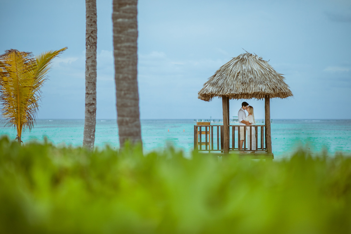 Noivos se beijando em praia do Caribe. Ensaio de romântico na praia realizado no resort Barceló Bávaro Palace na República Dominicana pelo fotógrafo de casamento Rafael Ohana