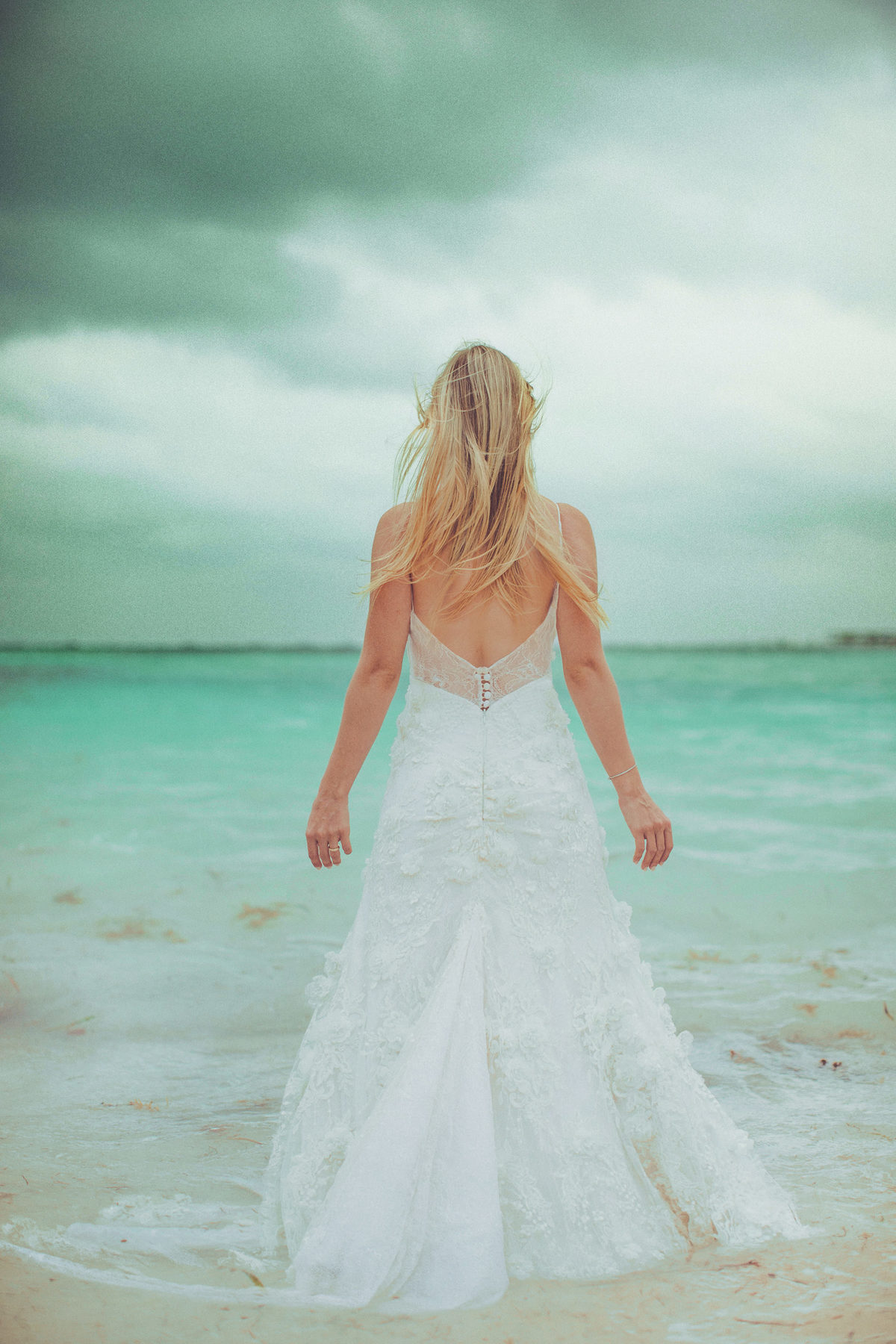 Noiva entrando na água do mar. Ensaio day after na praia realizado no resort Barceló Bávaro Palace na República Dominicana pelo fotógrafo de casamento Rafael Ohana