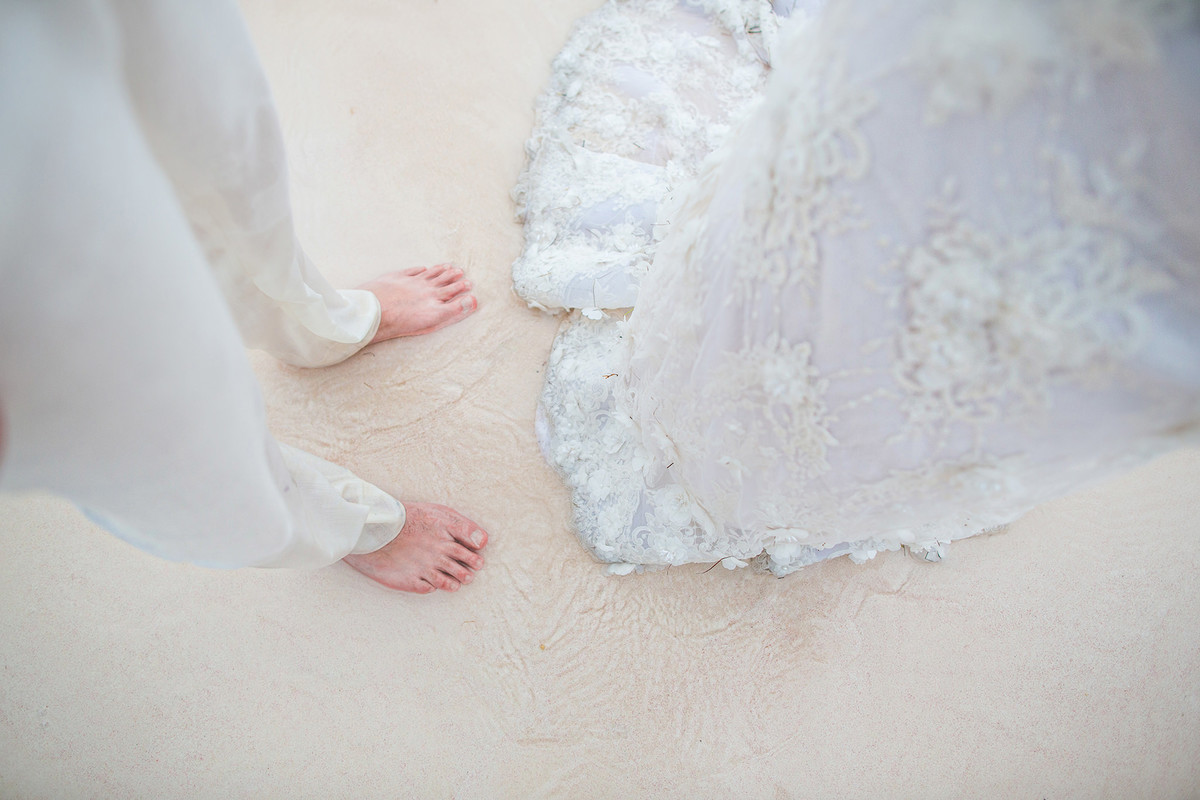 Noivos com os pés descalços. Ensaio day after na praia realizado no resort Barceló Bávaro Palace na República Dominicana pelo fotógrafo de casamento Rafael Ohana