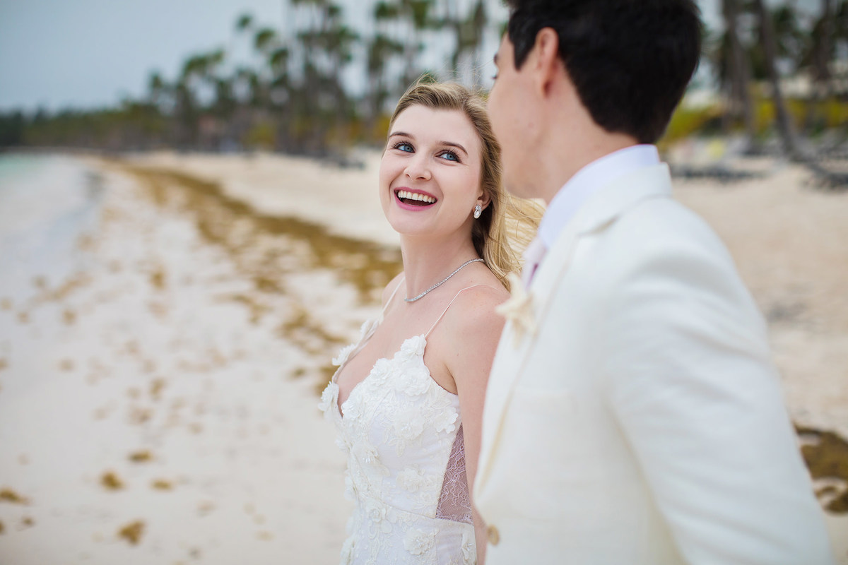 Noiva rindo com noivo. Ensaio day after na praia realizado no resort Barceló Bávaro Palace na República Dominicana pelo fotógrafo de casamento Rafael Ohana