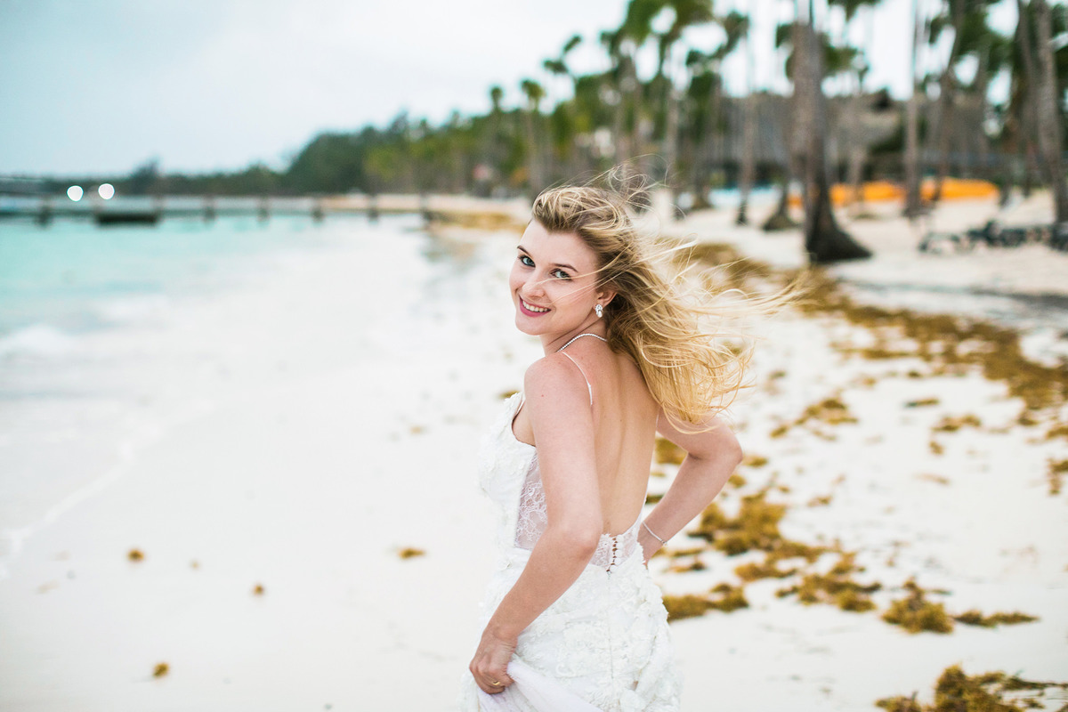 Noiva correndo pela praia. Ensaio day after na praia realizado no resort Barceló Bávaro Palace na República Dominicana pelo fotógrafo de casamento Rafael Ohana