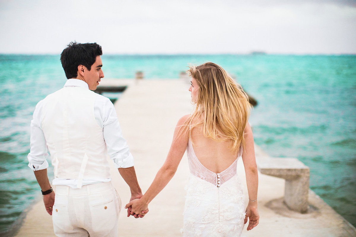 Noivos caminhando pela praia de Bávaro. Ensaio day after na praia realizado no resort Barceló Bávaro Palace na República Dominicana pelo fotógrafo de casamento Rafael Ohana