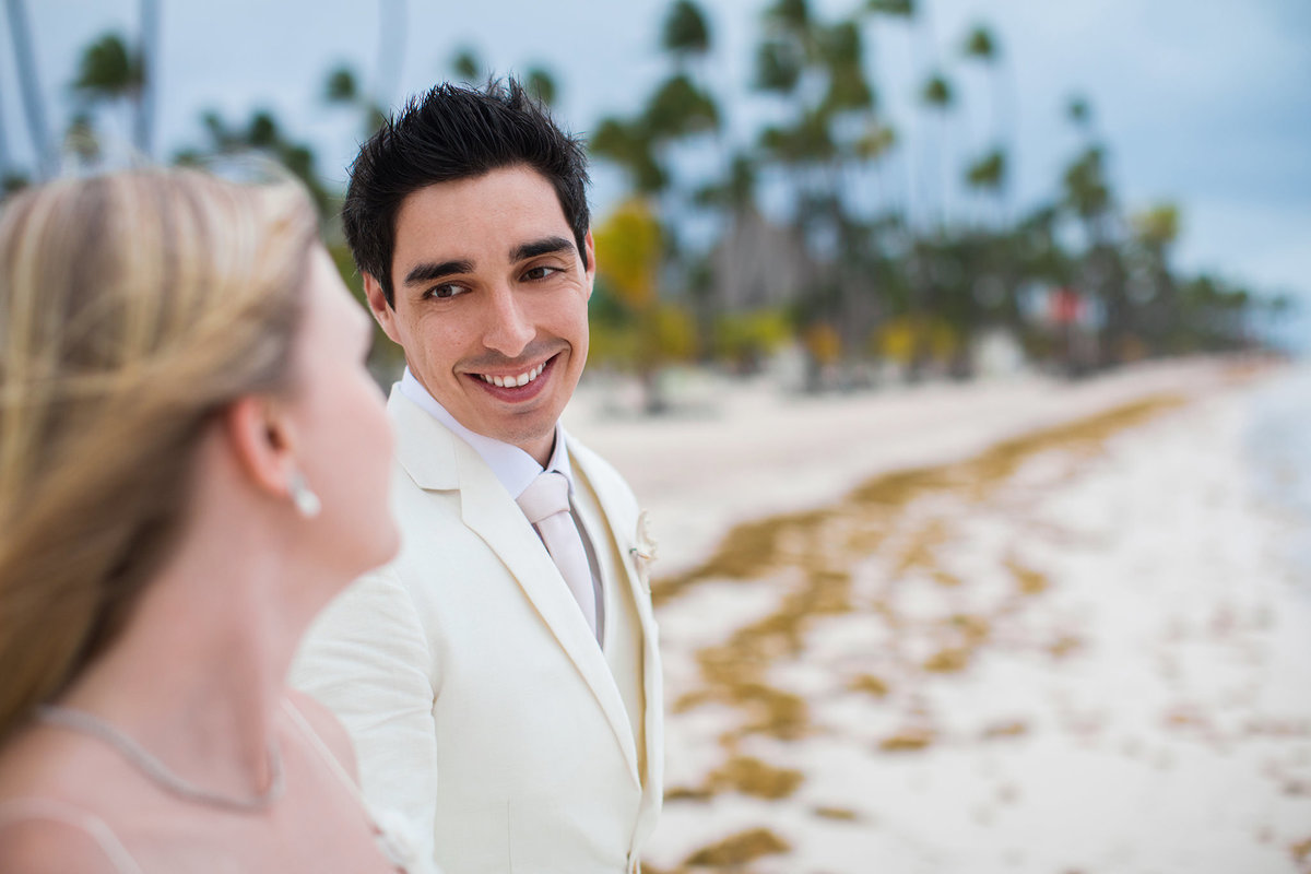 Noivo rindo com a noiva. Ensaio day after na praia realizado no resort Barceló Bávaro Palace na República Dominicana pelo fotógrafo de casamento Rafael Ohana