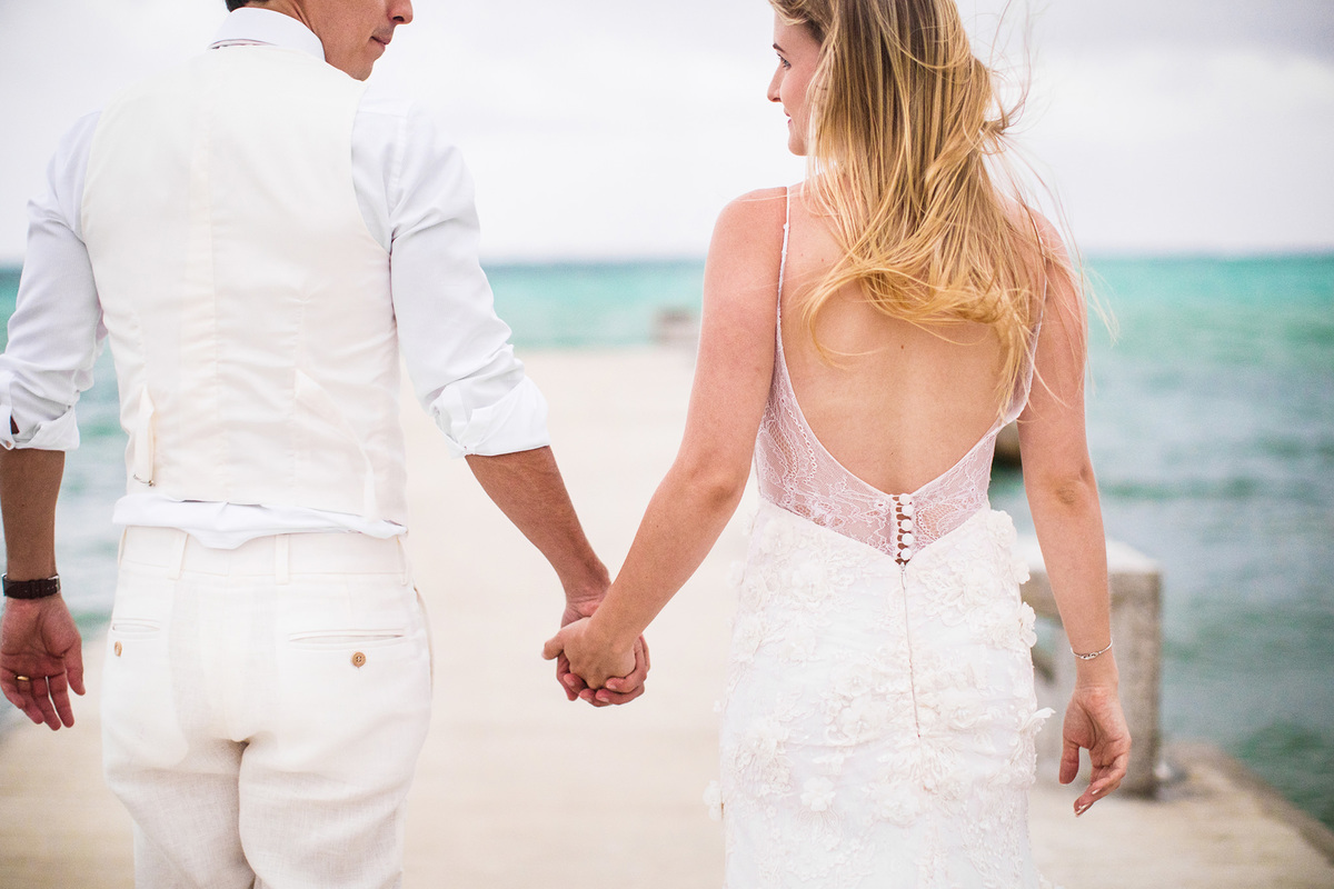 Noivos caminhando. Ensaio day after na praia realizado no resort Barceló Bávaro Palace na República Dominicana pelo fotógrafo de casamento Rafael Ohana
