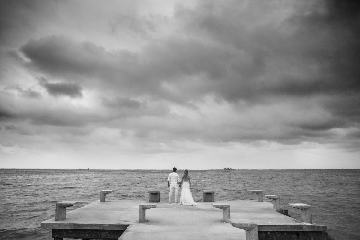 Noivos olhando o mar. Ensaio day after na praia realizado no resort Barceló Bávaro Palace na República Dominicana pelo fotógrafo de casamento Rafael Ohana