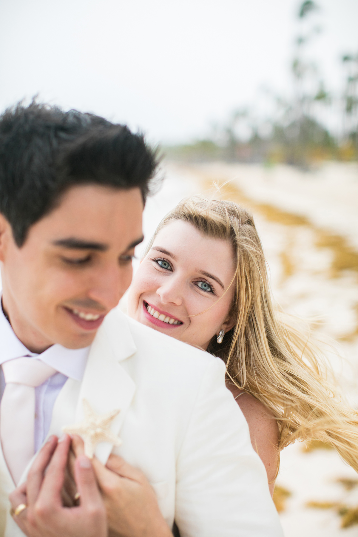 Noiva linda e loira sorrindo. Ensaio day after na praia realizado no resort Barceló Bávaro Palace na República Dominicana pelo fotógrafo de casamento Rafael Ohana
