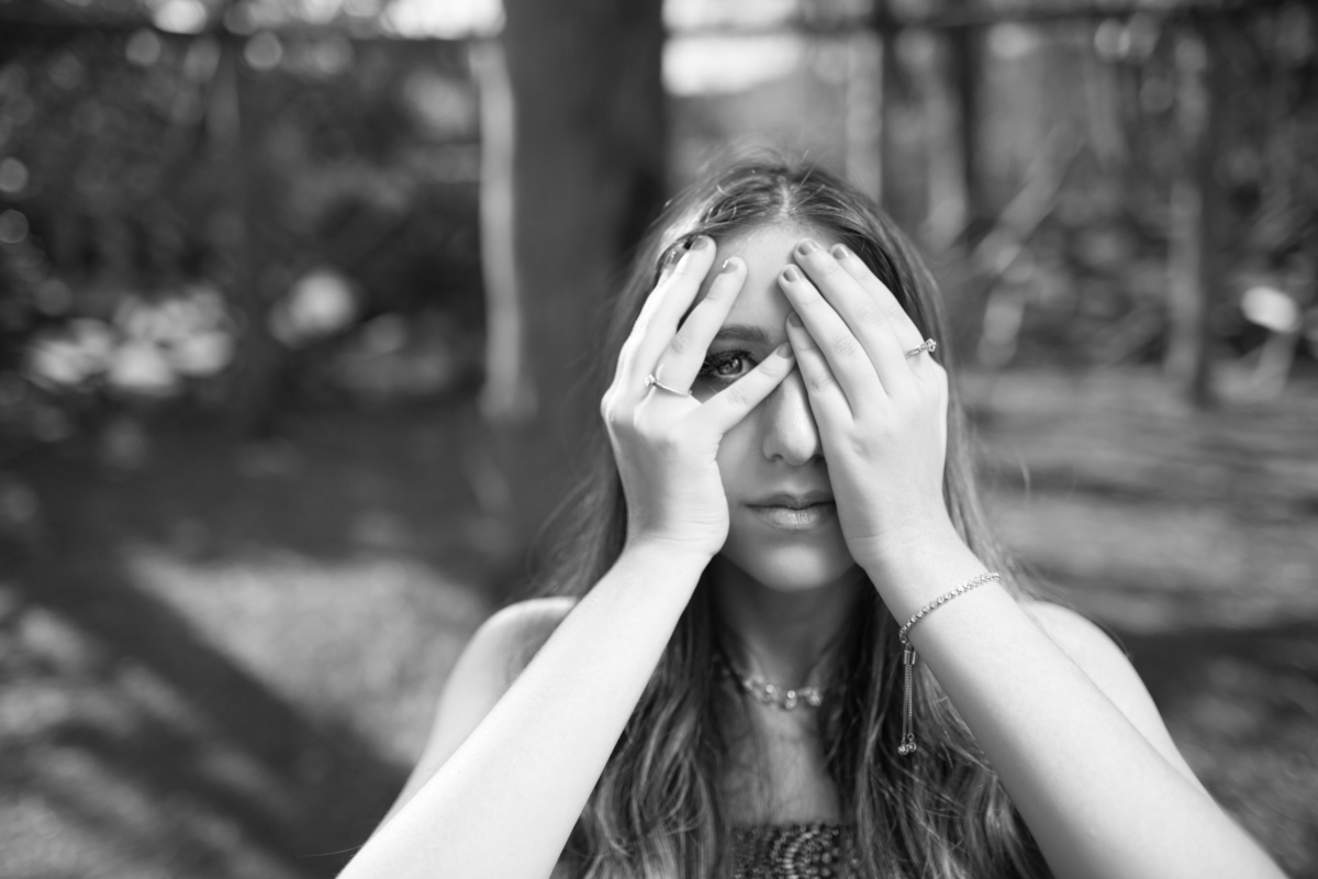 Debutante tampando o rosto. Ensaio de debutante feito no Jardim Botânico de Brasília pelo fotógrafo Rafael Ohana