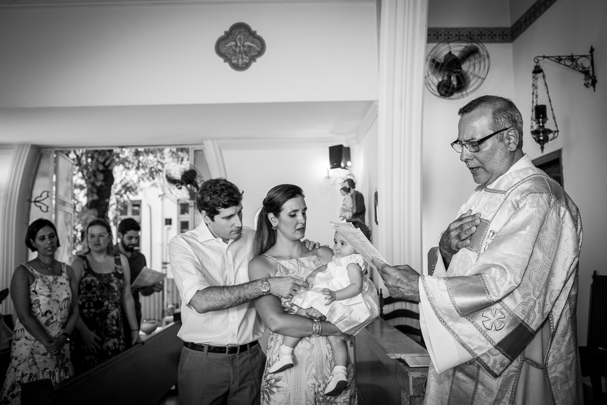 o padre, os pais e a gabi durante a cerimônia de batismo